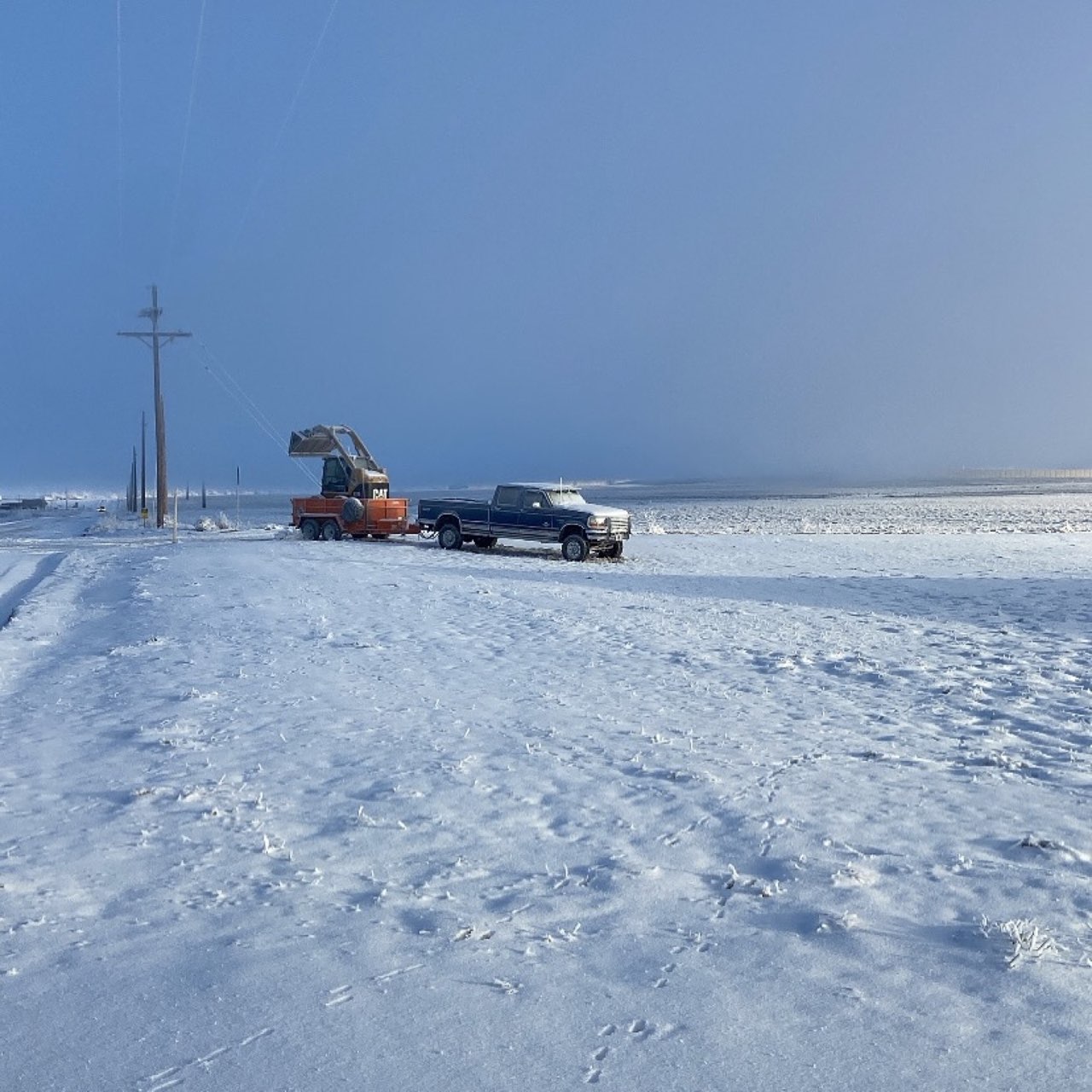 CAT skid steer with blade in Colorado snow — winter service