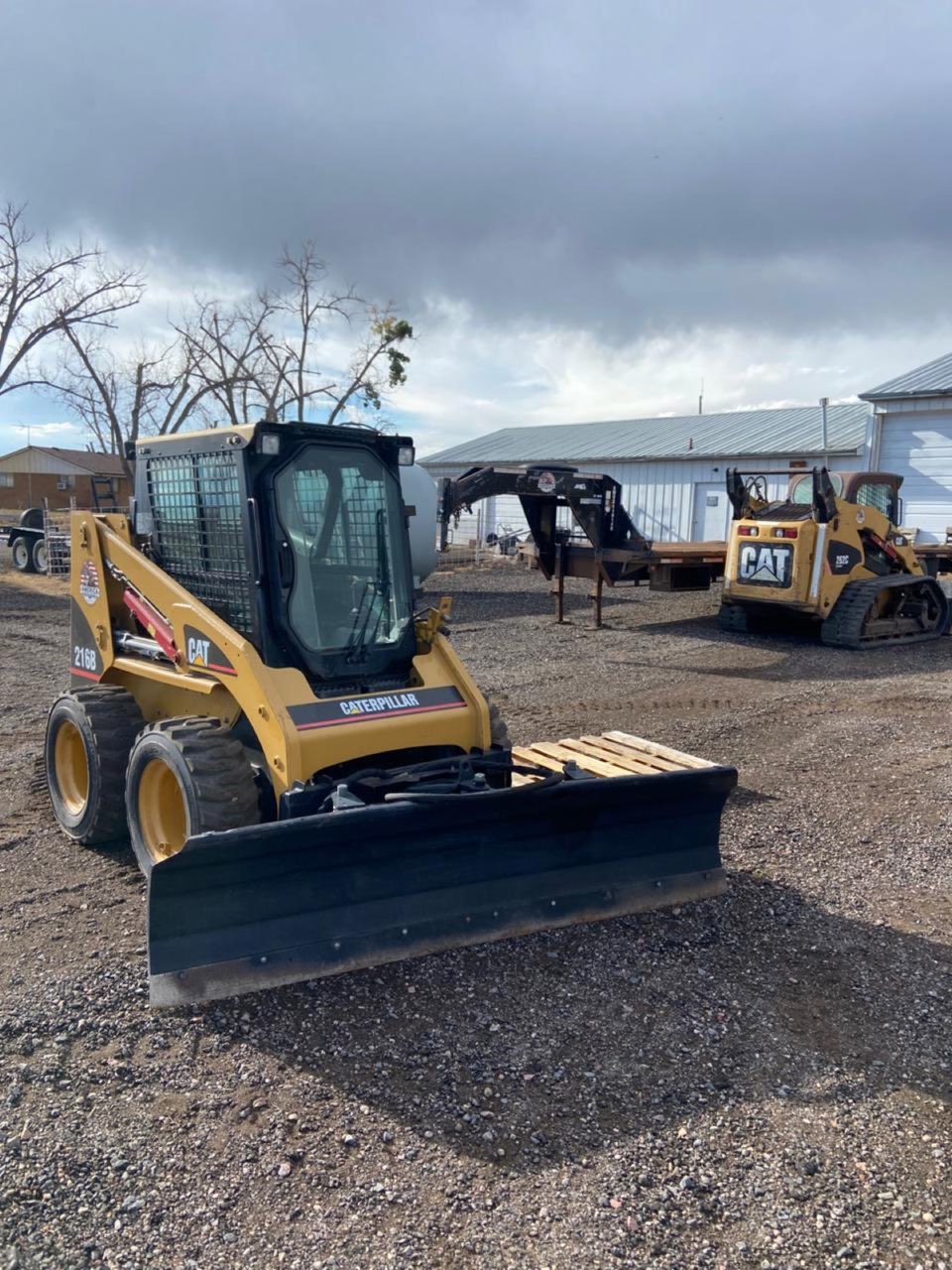 CAT 216B skid steer fitted with a snow blade, prepped for the 2026-27 season